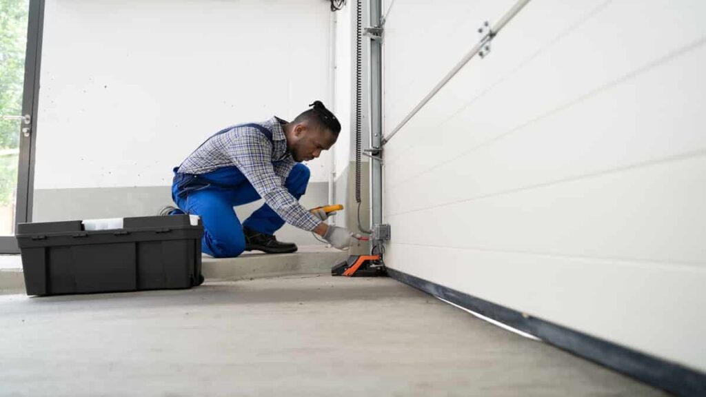 Een professional is onderhoud aan het doen op een garagepoort