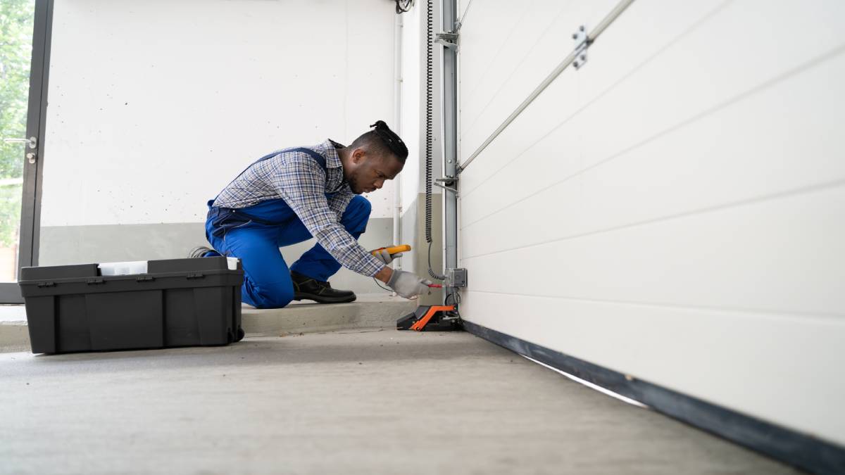 Een professional is onderhoud aan het doen op een garagepoort.